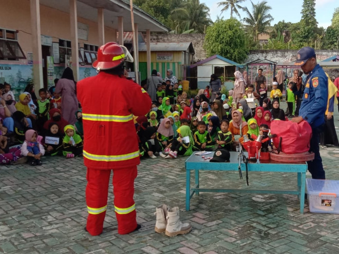Petugas damkar menjelaskan peralatan kepada siswa